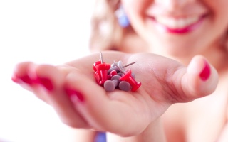 Woman smiling and holding straight pins