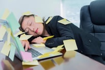 Businesswoman sleeping in office, with many adhesive notes on laptop.